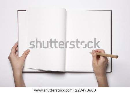 A woman(female) two hands hold a empty(blank) book(note, diary) spread(unfold) with wooden pencil isolated white, top view, studio.