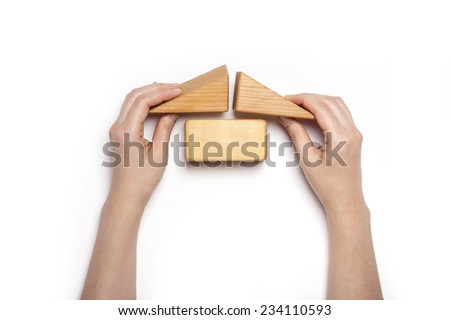 A female hand hold(pick up) the wood blocks like house(real estate) isolated white, top view at the studio.
