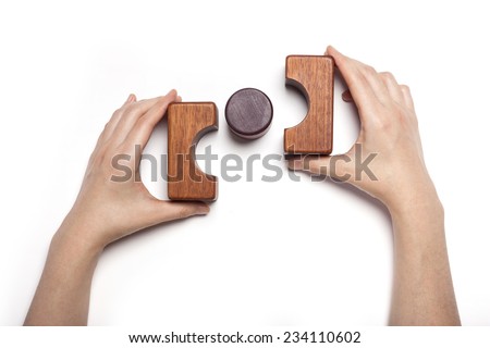 A female hand hold(pick up) the wood block among the wood blocks isolated white, top view at the studio.