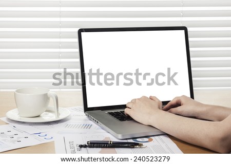 A working wooden desk(table) with notebook computer, coffee cup, paper, pencil and hand behind white blind(roller blind, shade).