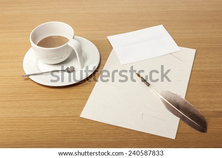 A coffee cup, feather quill pen, letter, envelope on the office desk(table).