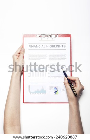 A female(woman) hand hold a pen and red clipboard with graph paper(document, report) isolated white, top view at the studio.