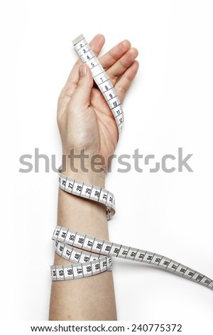 A female(woman) hand hold(reel, coil) a tape measure(tape line) isolated white at the studio.