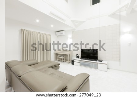 A white interior with leather sofa, internet TV, piano on the marble.