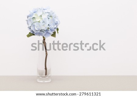A light blue hydrangea(Hydrangea macrophylla for. otaksa) for wedding bouquet in the glass cup on the paper table(desk) in the studio.