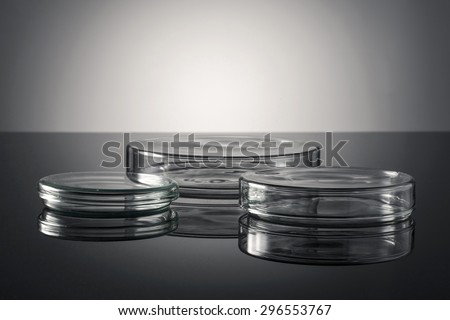 Three empty(blink) petri dish(Schale) on the reflected black desk in the laboratory