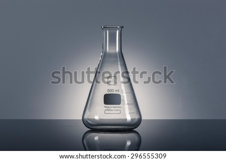 A glass empty(blink) Erlenmeyer flask on the reflected black desk in the laboratory