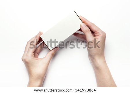 A woman hands hold a empty(blank, vacant, hollow) white paper box(package) for cosmetics, accessory, top view isolated white at the studio.