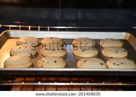 home made chocolate chip cookies baking in a hot oven half done still rising