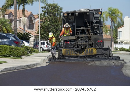 IRVINE, CA - AUGUST 06, 2014: Irvine\'s residential street rehabilitation and slurry seal project finished with crews expertly applying the emulsified asphalt (slurry seal).