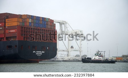 OAKLAND, CA - NOVEMBER 22, 2014: American Navigation (AmNav) Tugboat SANDRA HUGH to the stern of American President Lines (APL) Container ship BARCELONA, assisting the ship out of the Port of Oakland.