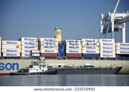 OAKLAND, CA - NOVEMBER 27, 2014: Foss POINT VINCENTE Tug Boat providing services to Matson Cargo Ship MAHIMAHI at the Port of Oakland. Foss provides marine transportation and logistical services.