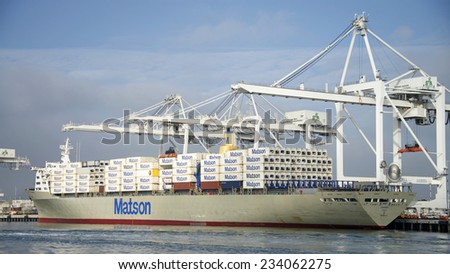 OAKLAND, CA - NOVEMBER 28, 2014: Port of Oakland, shipping containers being loaded on a Matson cargo ship. Matson provides shipping services Pacific wide, mainly to and from the Hawaiian Islands.