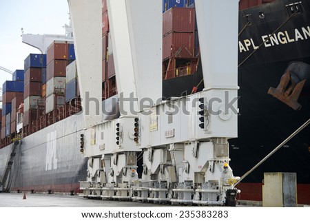 OAKLAND, CA - DECEMBER 04, 2014: Super Post Panamax cranes at the Port of Oakland can be repositioned on the dock to line the cranes spreader up with the section the containers will go in on the ship.