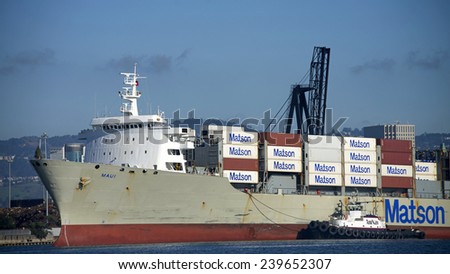 OAKLAND, CA - DECEMBER 22, 2014:  Matson Cargo Ship MAUI, with a Christmas tree attached to the Forward Bow, is escorted into the Port of Oakland with AmNav Tugboat LIBERTY on the port side.