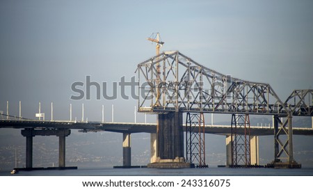 OAKLAND, CA - JANUARY 10, 2015: Deconstruction on the retired east span of the Bay Bridge continues. The entire cantilever section is scheduled to be removed down to the water line by late 2016.