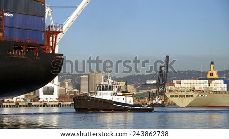 OAKLAND, CA - JANUARY 12, 2015: APL Cargo Ship KOREA passing Matson Cargo Ship MANOA while both ships enter the Port of Oakland. Tugboats efficiently assist the giant ships through the port safely.