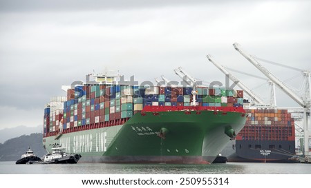 OAKLAND, CA - FEBRUARY 07, 2015: CSCL Cargo Ship YELLOW SEA, built in 2014, has a Gross Tonnage of 116,568. The vessels size necessitates the use of Four Tugboats to assist it to the Port of Oakland.