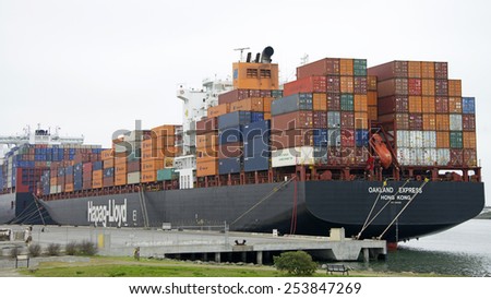 OAKLAND, CA - FEBRUARY 17, 2015: Hapag-Lloyd Cargo Ship OAKLAND EXPRESS docked a the Port of Oakland. The ship is fully loaded with no cranes, trucks or workers on the docks.