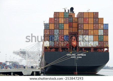 OAKLAND, CA - FEBRUARY 17, 2015: Hapag-Lloyd Cargo Ship OAKLAND EXPRESS docked a the Port of Oakland. The ship is fully loaded with no cranes, trucks or workers on the docks.