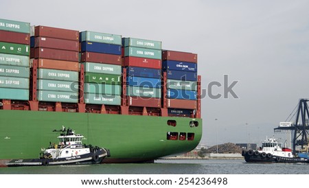 OAKLAND, CA - FEBRUARY 19, 2015: Tugboats Z-FOUR and VETERAN assisting CSCL SPRING into the Port of Oakland. Tugs move vessels that should not move themselves, such as ships in a crowded harbor.