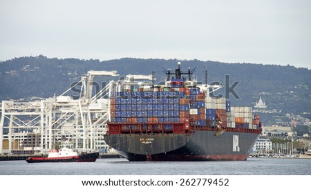 OAKLAND, CA - MARCH 21, 2015: APL Cargo Ship CHINA entering the Port of Oakland with Tugboat VALOR assisting from the Stern.