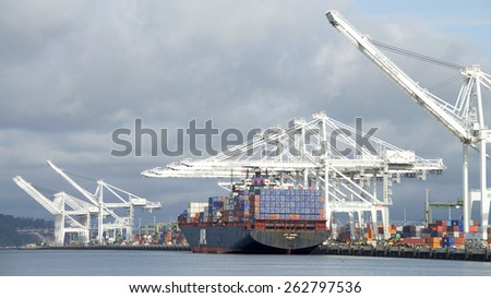 OAKLAND, CA - MARCH 22, 2015: APL Cargo Ship CHINA loading at the Port of Oakland.  American President Lines (APL) is the worlds seventh largest container transportation and shipping company.