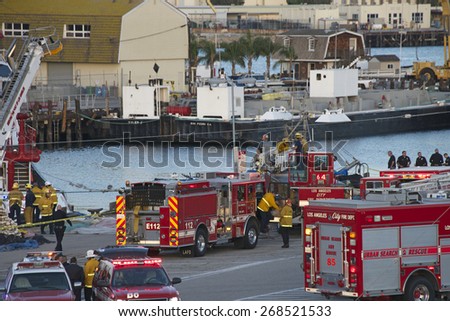 SAN PEDRO, CA - APRIL 09, 2015: Rescue operations underway as the sun goes down at the Port of Los Angeles where a vehicle with a family inside veered off the dock into the water at Berth 73.