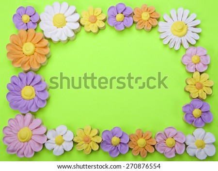 Sugar Cookies fancy home made flowers border isolated on a green background with room for your text in the center