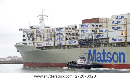 OAKLAND, CA - APRIL 22, 2015:  AmNav Tugboat PATRICIA ANN on the port side of Matson Cargo Ship MOKIHANA, assisting it to maneuver into the Port of Oakland.