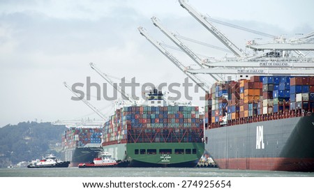 OAKLAND, CA - MAY 03, 2015: China Shipping Lines Cargo Ship CSCL SPRING entering the Port of Oakland. Tugboats push the vessel sideways to the dock.