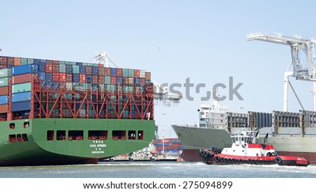 OAKLAND, CA - MAY 03, 2015: China Shipping Lines Cargo Ship CSCL SPRING entering the Port of Oakland with Tugboat VALOR at the stern.