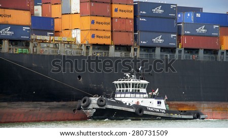 OAKLAND, CA - MAY 14, 2015: Tugboat Z-THREE off the Port side of APL Cargo Ship DIANA, assisting the vessel to maneuver out of the Port of Oakland.