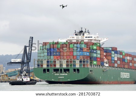 OAKLAND, CA - MAY 22, 2015: Cargo Ship EVER CHAMPION entering the Port of Oakland. A drone suddenly flew closely behind the ship, video taping the ships entry to the Port.