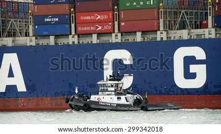 OAKLAND, CA - JULY 22, 2015: Tugboat Z-THREE off the Port side of CMA CGM Cargo Ship LIBRA, assisting the vessel to maneuver to the Port of Oakland.