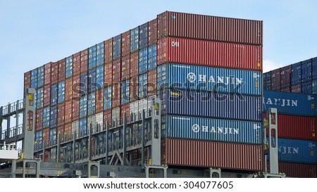 OAKLAND, CA - AUGUST 05, 2015: Over 90 percent of the world\'s trade is carried by sea. Shipping Containers stacked on a cargo ship, organized and placed algorithmically for efficient transport.