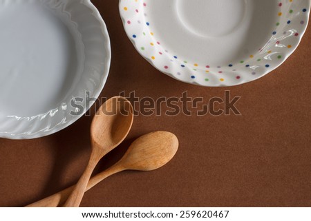 old wooden cooking spoon with small plate put on brown paper background