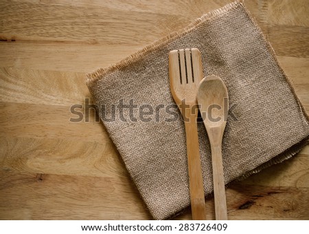 Serving spoons on burlap cloth on wooden surface image brown tone