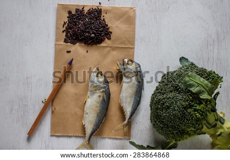 fresh mackerel or tuna steamed fish with riceberry on vintage white table and paper for notes