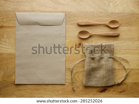Burlap bag and paper bag with wooden spoon set. Object put on surface wood table. Image retro filter effect. Brown tone.