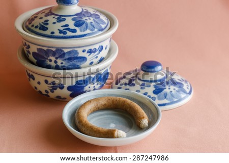 asia antique pattern style painting handmade on the blow ceramic (Porcelain), blue blow on pink cloth background. image soft focus and pastel tone.
