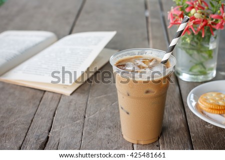 Glass of Cold Iced Coffee put on old wood table.