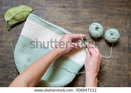 hand knitting crochet bag of green on a wooden table