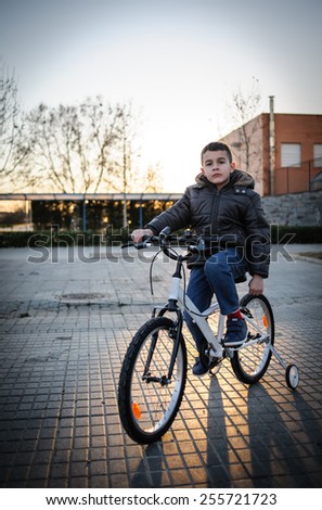 child riding bicycle with training wheels