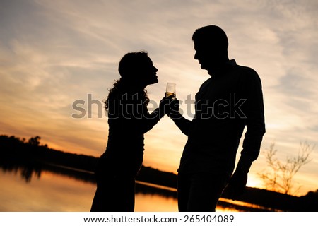 Silhouette of couple toasting at sunset