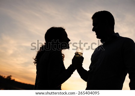 Couple toasting with champagne at sunset