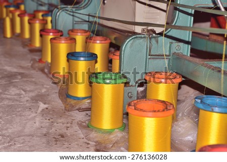 Textile industry Ã?Â¢?? yarn spools on spinning machine in a textile factory