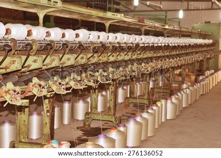 Textile industry Ã?Â¢?? yarn spools on spinning machine in a textile factory