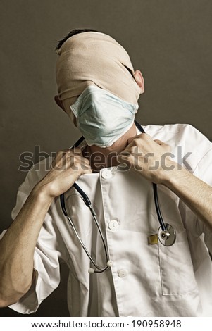 A covered face of a medic trying to broke his medical gown with his hands