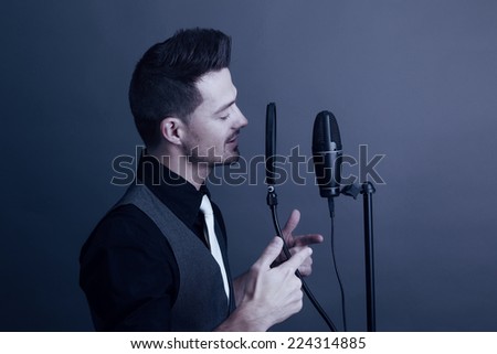 Guy singing at a microphone wearing a white tie
